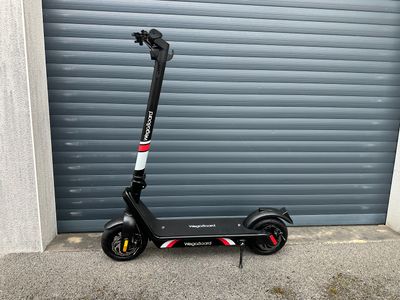 a scooter that is parked in front of a garage door