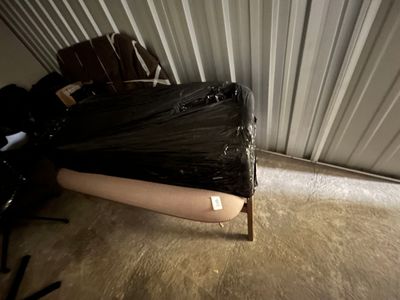 a bed that has been wrapped in plastic and is in the corner of a room
