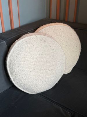 two round white sponges sitting on top of a black couch