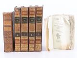plusieurs vieux livres posés les uns sur les autres sur une surface blanche