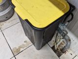 two kegs and a bucket on the floor in a room