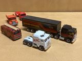 quatre camions miniatures et un semi-remorque posés sur une table