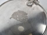 a silver plate with a picture on it on a table