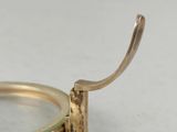a gold ring with a magnifying glass on it
