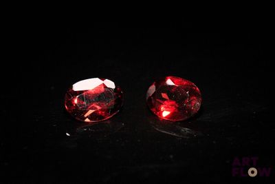 a pair of red gems on a black surface