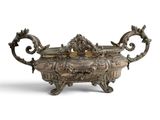 an ornate silverplated bowl with handles and handles on a stand