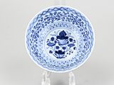 a blue and white plate with a flower design on it
