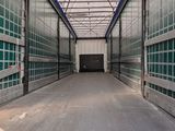 a long hallway in a storage building with green glass doors