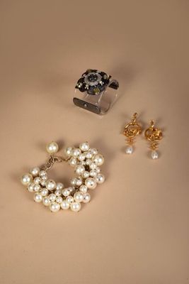 two pairs of earrings and a bracelet are sitting on a table
