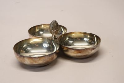 trois bols plaqués argent posés sur un plateau blanc, avec un oiseau sur l'un d'entre eux