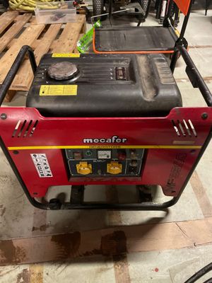 a red and black portable generator sitting on top of a wooden pallet