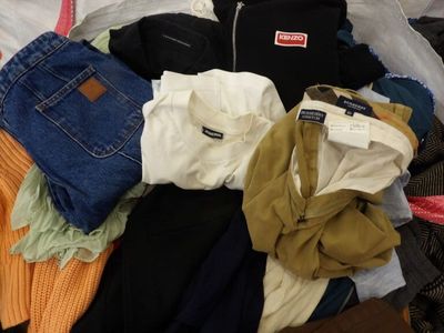 une pile de vêtements posée sur un lit
