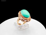 an image of a gold ring with a green stone on top of it