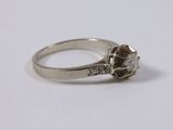 a close up of a diamond ring on a white surface