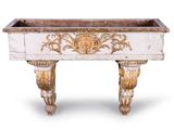 une jardinière blanche et dorée posée sur une table