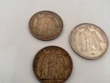 three coins sitting on top of a white surface next to each other