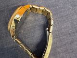 gold tone bracelet with black and orange accents on a gray surface