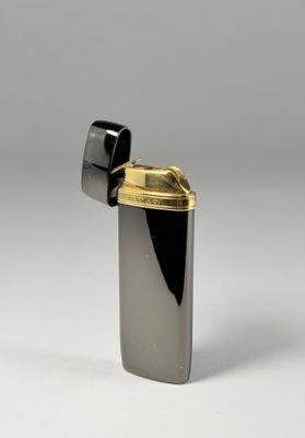 briquet noir et doré posé sur une surface blanche