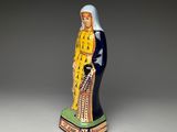 figurine of a woman in a blue and yellow dress holding a dog