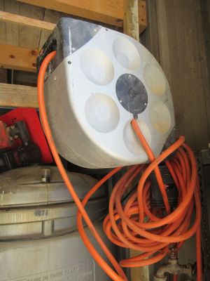 un tuyau orange raccordé à un réservoir blanc dans un garage