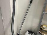 a vacuum that is sitting on the floor next to a shelf