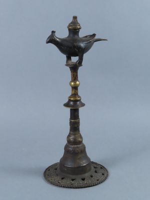 an old bronze lamp with a bird on top of it