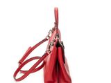 the red handbag is sitting on a white surface