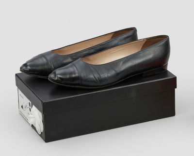 une paire de chaussures en cuir noir posée sur une boîte noire
