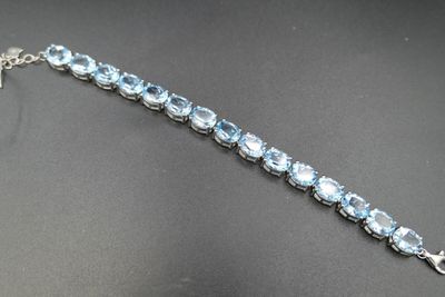 un gros plan d'un bracelet en argent orné de cristaux bleus