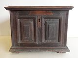 un petit meuble en bois surmonté d'une porte