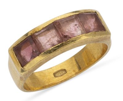 a close up of a gold ring with pink stones