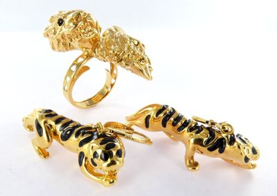 three gold rings with black and white enamel animals on them