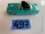 une petite voiture miniature avec une étiquette de prix posée sur la table