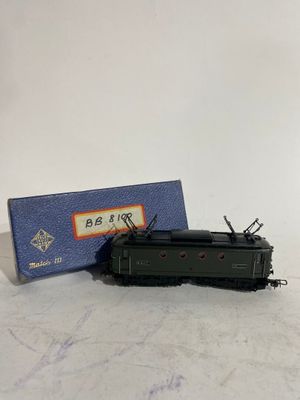 une image représentant un petit train jouet posé sur une table, à côté d'une boîte