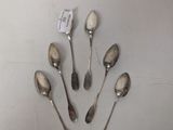 six spoons are arranged in a circle on a white surface