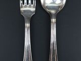 two spoons and a fork on a black table