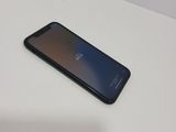 the back of a black phone sitting on top of a white table