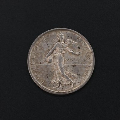a close up of a silver coin on a black surface