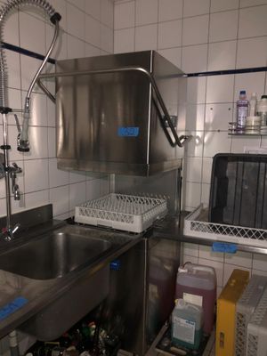 une cuisine équipée d'un évier, d'un lave-vaisselle et d'autres éléments posés sur le plan de travail