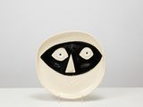 a black and white plate with a raccoon face on it
