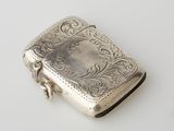 a silver cigarette case sitting on a white surface