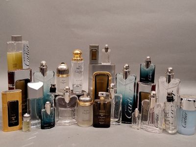 de nombreux flacons de parfum de styles variés posés sur une surface blanche