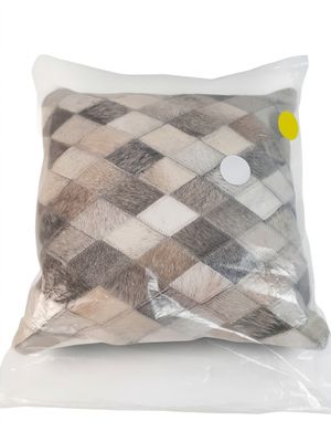un oreiller orné d'un motif à carreaux sur fond blanc