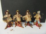 five figurines of people dressed in different costumes