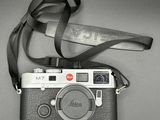 a black and white photo of a camera with a strap on it