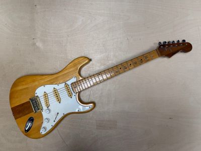 une guitare électrique posée sur une table en bois