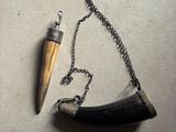 un collier orné d'une corne et d'une chaîne