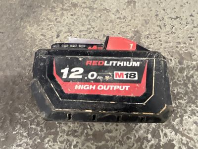 a close up of a red lithium battery on a concrete surface