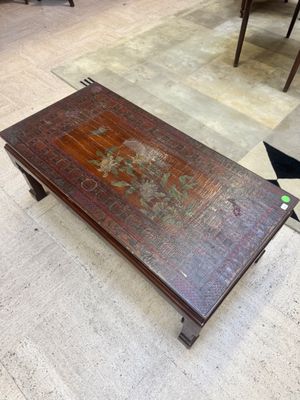 une table basse sur laquelle est posé un tableau, au milieu d'une pièce
