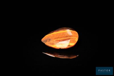 une pierre de quartz jaune posée sur une surface noire